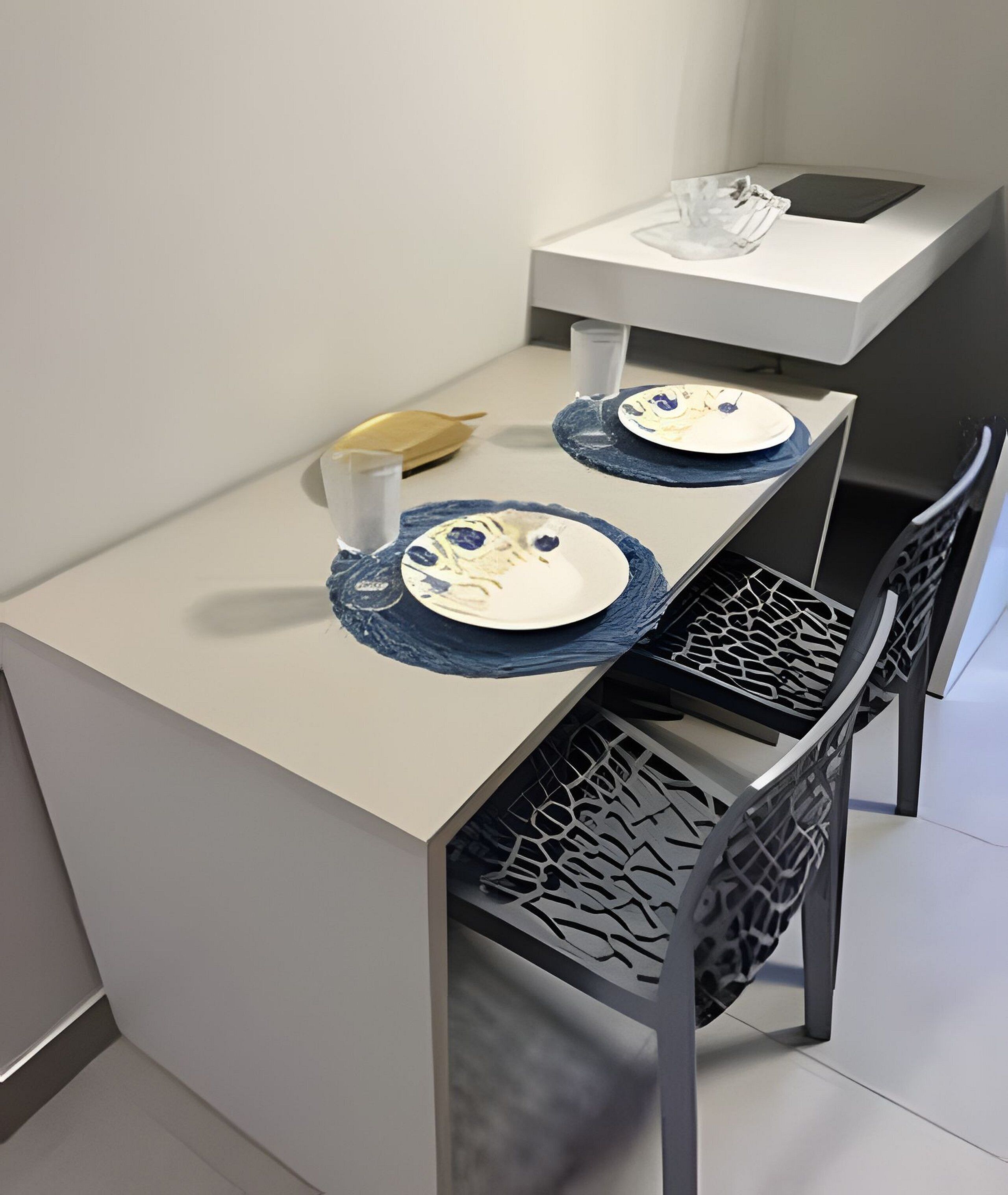 Una pequeña mesa de comedor con dos platos, un vaso y una banana.