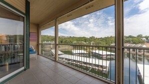 Un balcón con vista al río, una silla y una bandera.