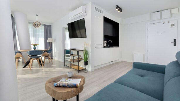 A modern living room with a sofa, a coffee table, and a TV. - Wavescape - Wave Resort & Spa (Międzyzdroje)