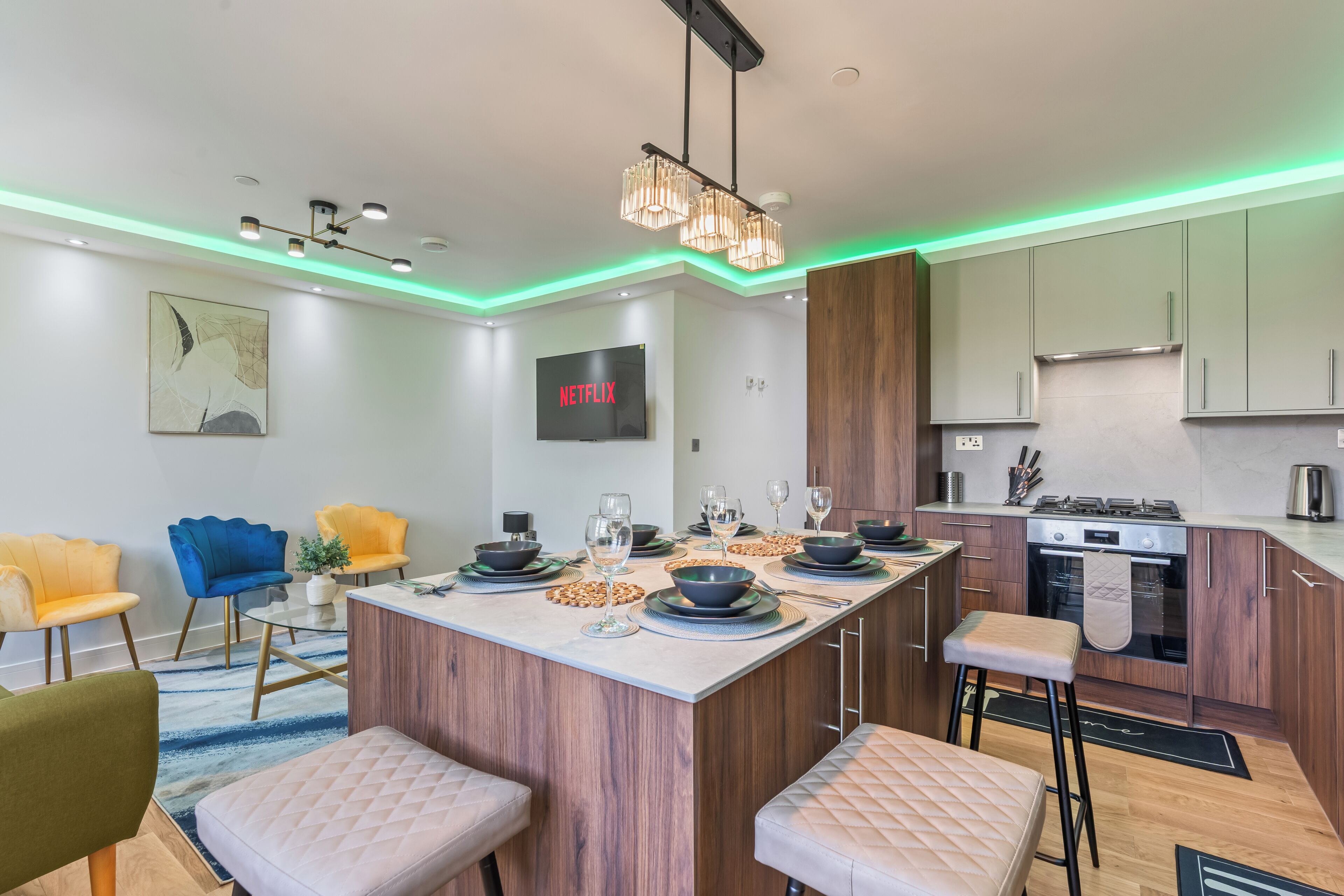 Una cocina moderna con una isla central, armarios de madera y un horno empotrado.