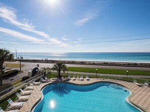 Ein Schwimmbad mit Blick auf den Ozean und eine Straße.