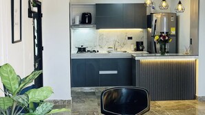 A modern kitchen with a marble countertop, a built-in oven, and a refrigerator. - Luxury Aparment in Chinacota With Studio Perfect for Remote Work (Chinacota)