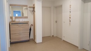 A hotel room with a wooden vanity, a mirror, a door, and a wall-mounted decoration. - Gerdes family vacation apartment in Waldenburg - good living in a quiet location (Waldenburg)