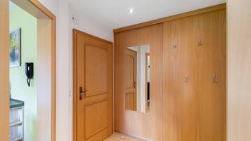 A hallway with wooden doors, a mirror, and a telephone.