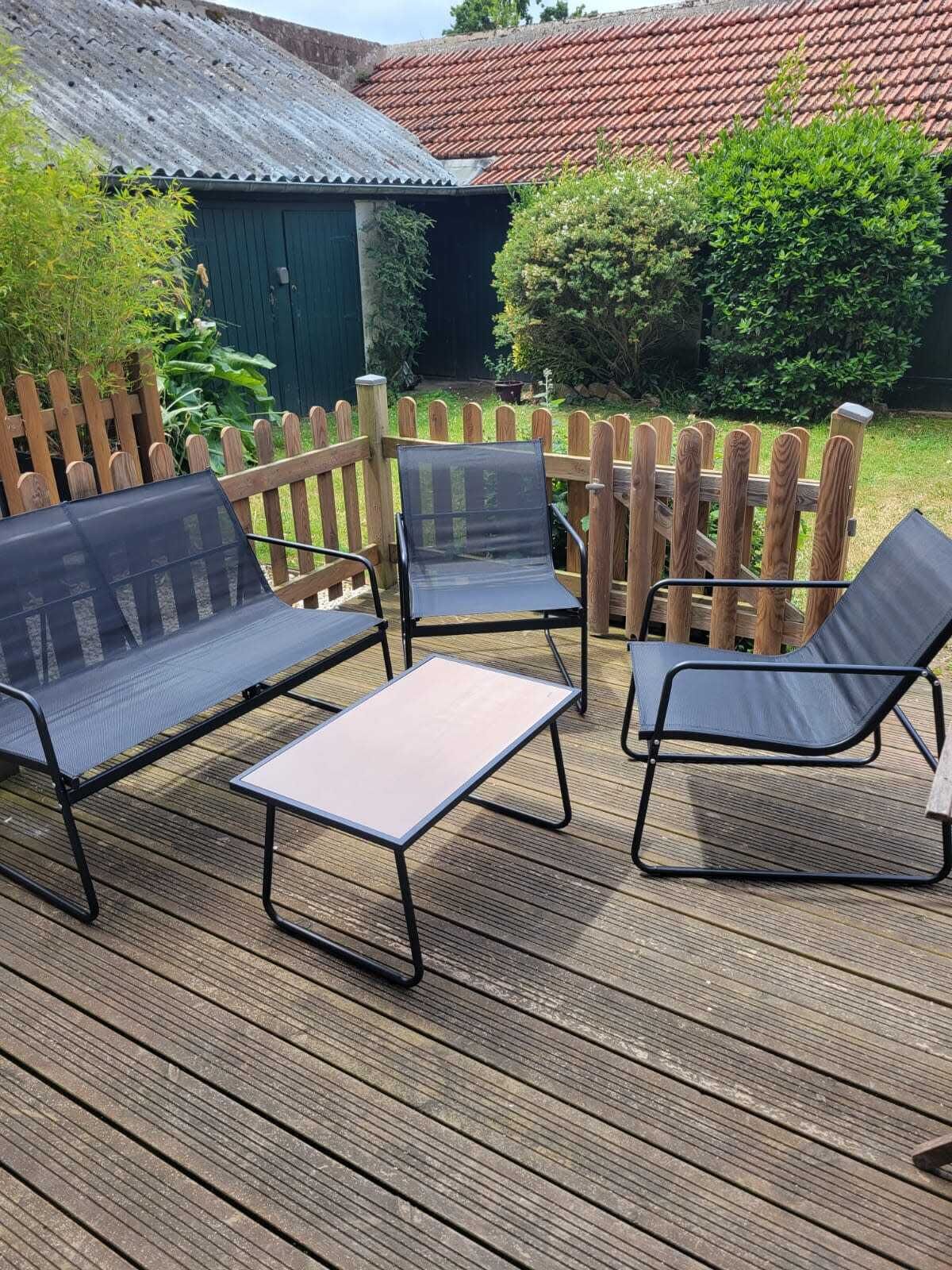 A wooden deck with a metal table and two chairs.