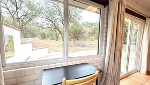 A room with a window, a table, and a chair.