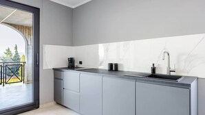 A modern kitchen with a built-in sink, a coffee maker, and cabinets. - Brà Apartments & Lofts - Suite 1 | Verona Fiere (Verona)