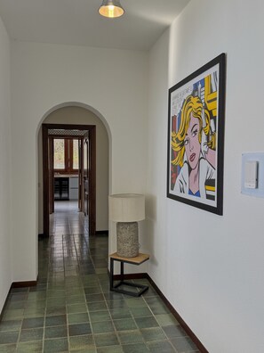 A hallway with a lamp, a framed artwork, and a tiled floor. - Comfortable lakefront family apartment (GERA LARIO)