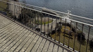 Un balcone con vista su un lago, montagne e cielo sereno.