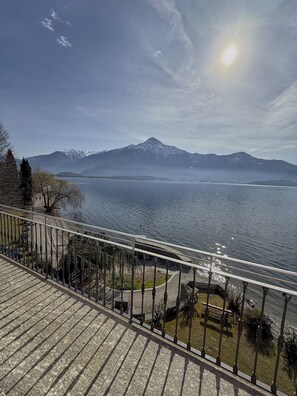 A balcony with a view of a lake, mountains, and a clear sky. - Comfortable lakefront family apartment (GERA LARIO)