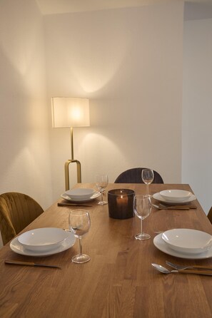A dining table set with plates, glasses, and cutlery, a lamp, and a candle. - Quiet lakefront apartment (GERA LARIO)