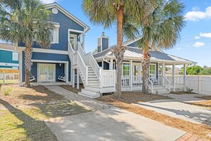 A two-story house with a covered porch, a staircase, and a fenced yard. - 12BDR Luxury Estate For Large Groups (Destin)