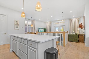 A spacious kitchen with a large island, pendant lights, and a view to the dining area. - 12BDR Luxury Estate For Large Groups (Destin)