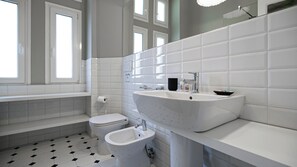 A bathroom with a bathtub, toilet, and sink, all in white. - Italianway Comfort - Montello 12 (Milan)