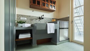 Een badkamer met een granieten werkblad, een handdoekhouder, een kast en een raam met uitzicht.