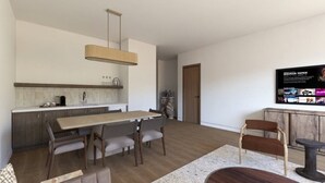 A modern kitchen with a dining area, a TV mounted on the wall, and a wooden floor. - Scottsdale Golf Retreat at Troon North, 4-bedroom suite with king bed and bath (Scottsdale)