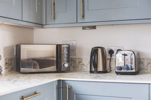 A kitchen with a built-in microwave, a kettle, and a toaster on a marble countertop. - Spacious 2BDR 2Bath Apt with Parking Near Heathrow (Greater London)