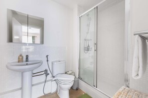 Une salle de bain avec un lavabo, des toilettes et une douche.