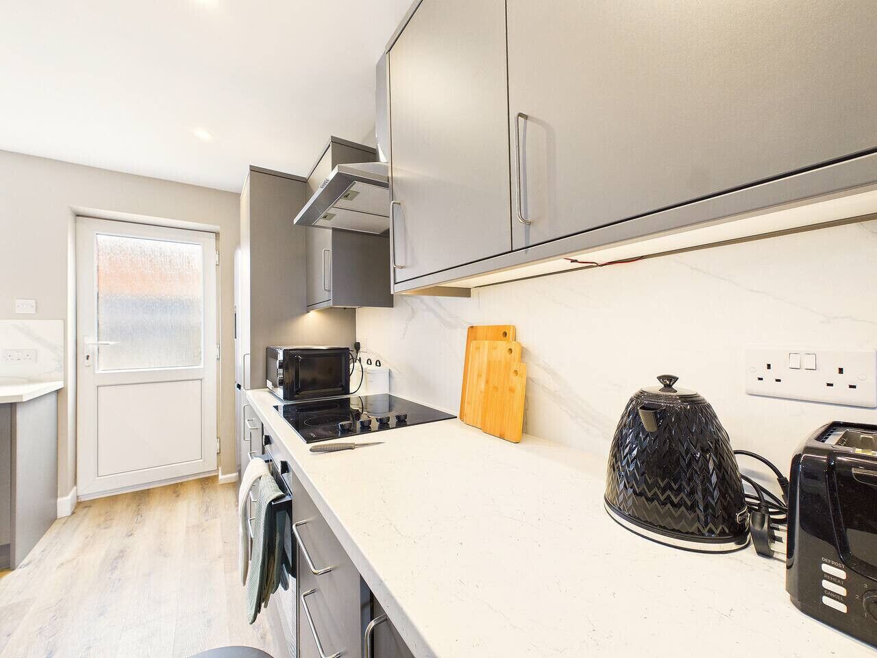 A modern kitchen with a microwave, stove, and toaster.