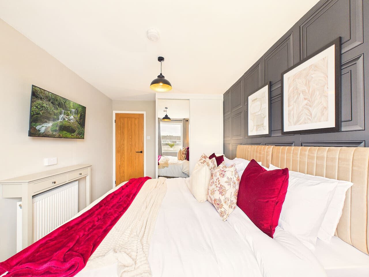 Ein Schlafzimmer mit einem Bett, einem Heizkörper, einem Spiegel und einer Tür zu einem anderen Raum.