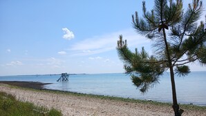 Une plage avec une structure en bois, un ciel dégagé et une eau calme.