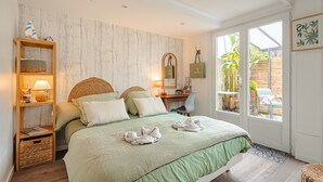 Une chambre à coucher avec un lit, des tables de chevet, un bureau et une chaise.