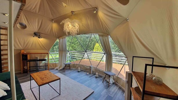 A tent with a wooden table, a bench, and a hanging light fixture. - Hain Glamp Karkonosze – glamping tent with jacuzzi & sauna (Przesieka)