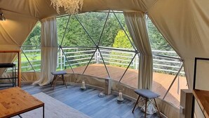 A tent with a wooden table, bench, and a hanging light fixture. - Hain Glamp Karkonosze – glamping tent with jacuzzi & sauna (Przesieka)