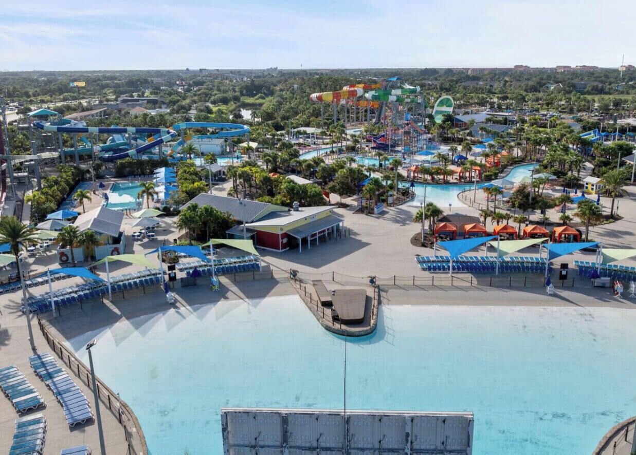 A water park with multiple slides, a large pool, and sun loungers.