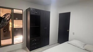 A bedroom with a bed, a wardrobe, and a door. - Family Apt in the South of Cali (Cali)