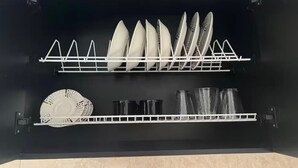 A kitchen with a dish rack holding plates and bowls, and a shelf with cups and glasses. - Family Apt in the South of Cali (Cali)