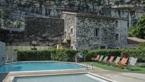 A swimming pool with a stone building in the background. - COTTAGE PARKS MEDROSE Ecolodge tent with sanitary facilities (Saint-Thomé)