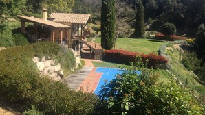 Une maison avec un patio, une piscine et un jardin.