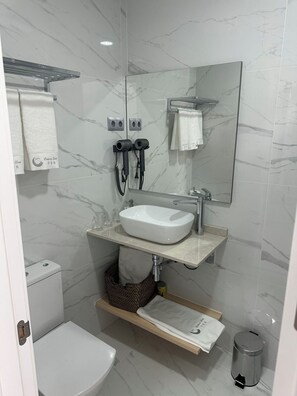 Habitación triple Deluxe | Baño | Secador de pelo, toallas, champú y papel higiénico