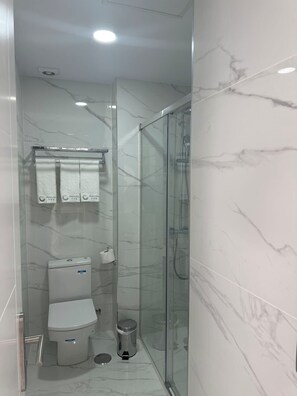 Quarto triplo luxo | Banheiro | Secador de cabelo, toalhas de banho, shampoo, papel higiênico