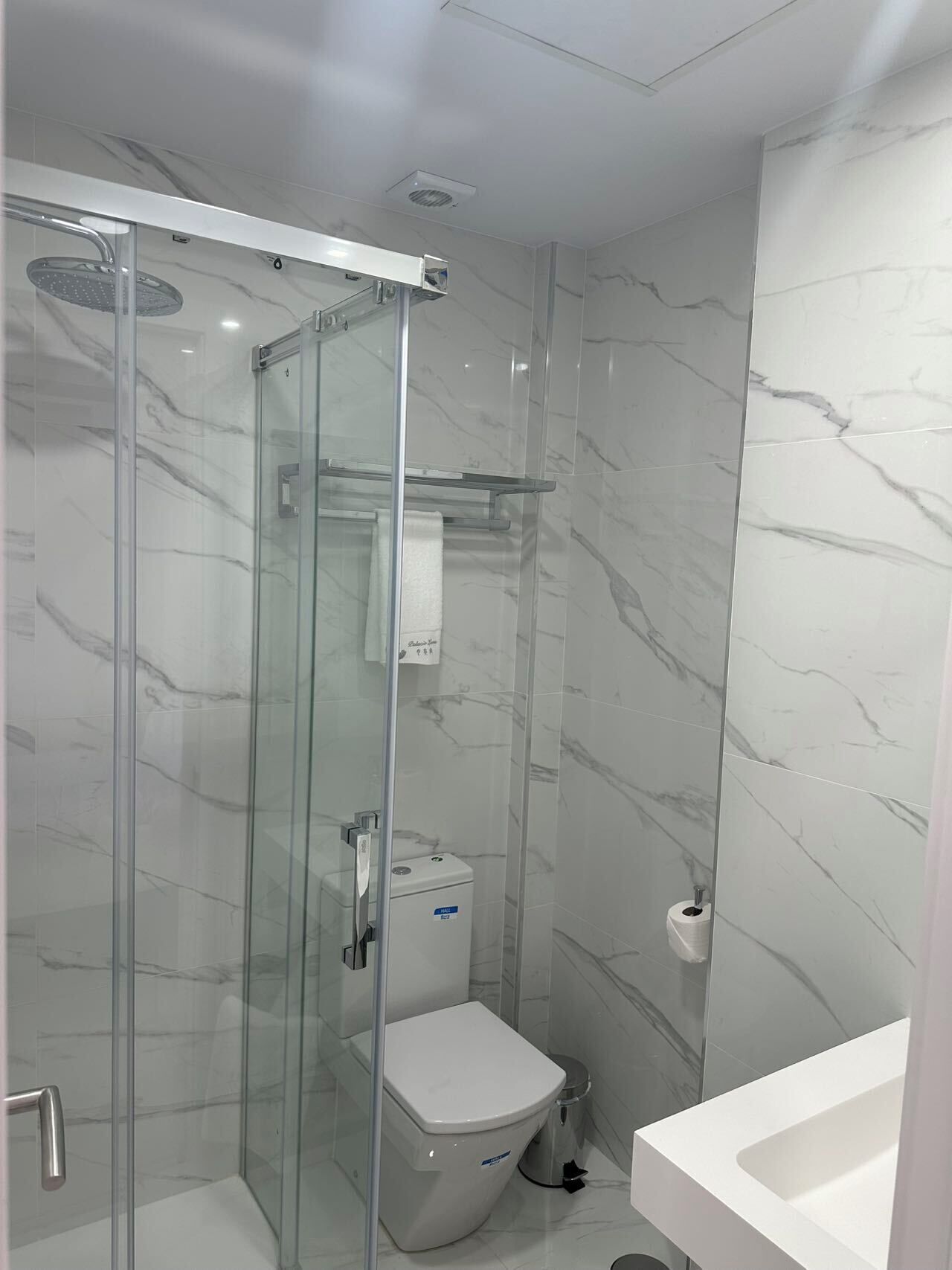 Comfort eenpersoonskamer | Badkamer | Een haardroger, handdoeken, shampoo, toiletpapier