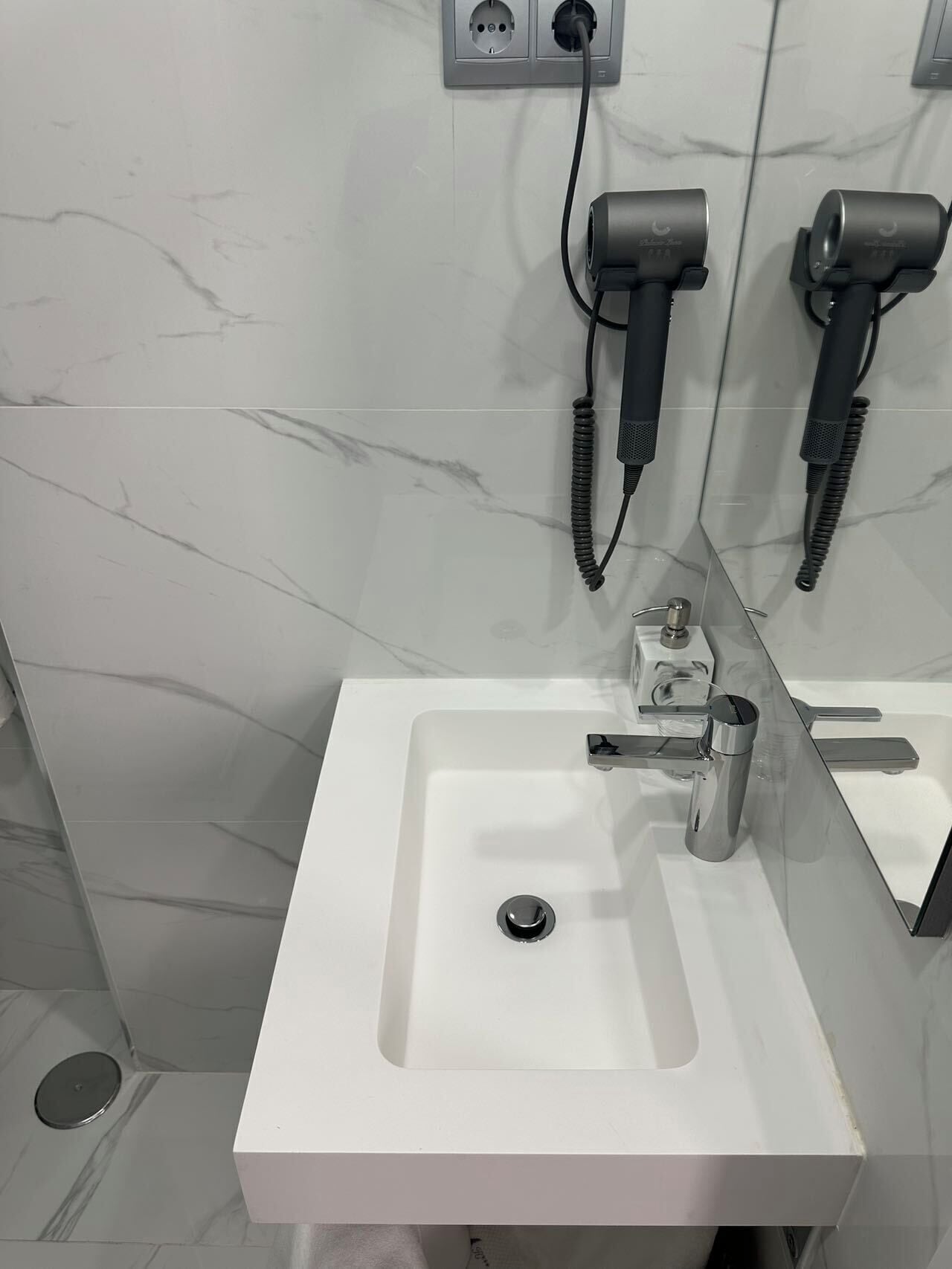 Comfort eenpersoonskamer | Badkamer | Een haardroger, handdoeken, shampoo, toiletpapier