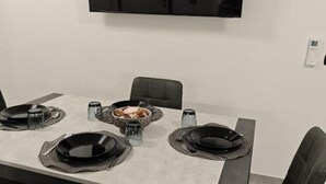 Ett matbord dukat med svarta tallrikar, en skål med mat samt salt- och pepparkar.