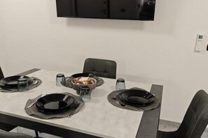 A dining table set with black plates, a bowl of food, and salt and pepper shakers. - Moder flat near assisi 2 minutes from airport & pool (Umbria)