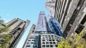A cluster of high-rise buildings with a modern architectural style, featuring reflective glass facades and varying heights. - Skyline & Sea Luxe Heated Pool, Gym, Sauna, Steam (Melbourne)