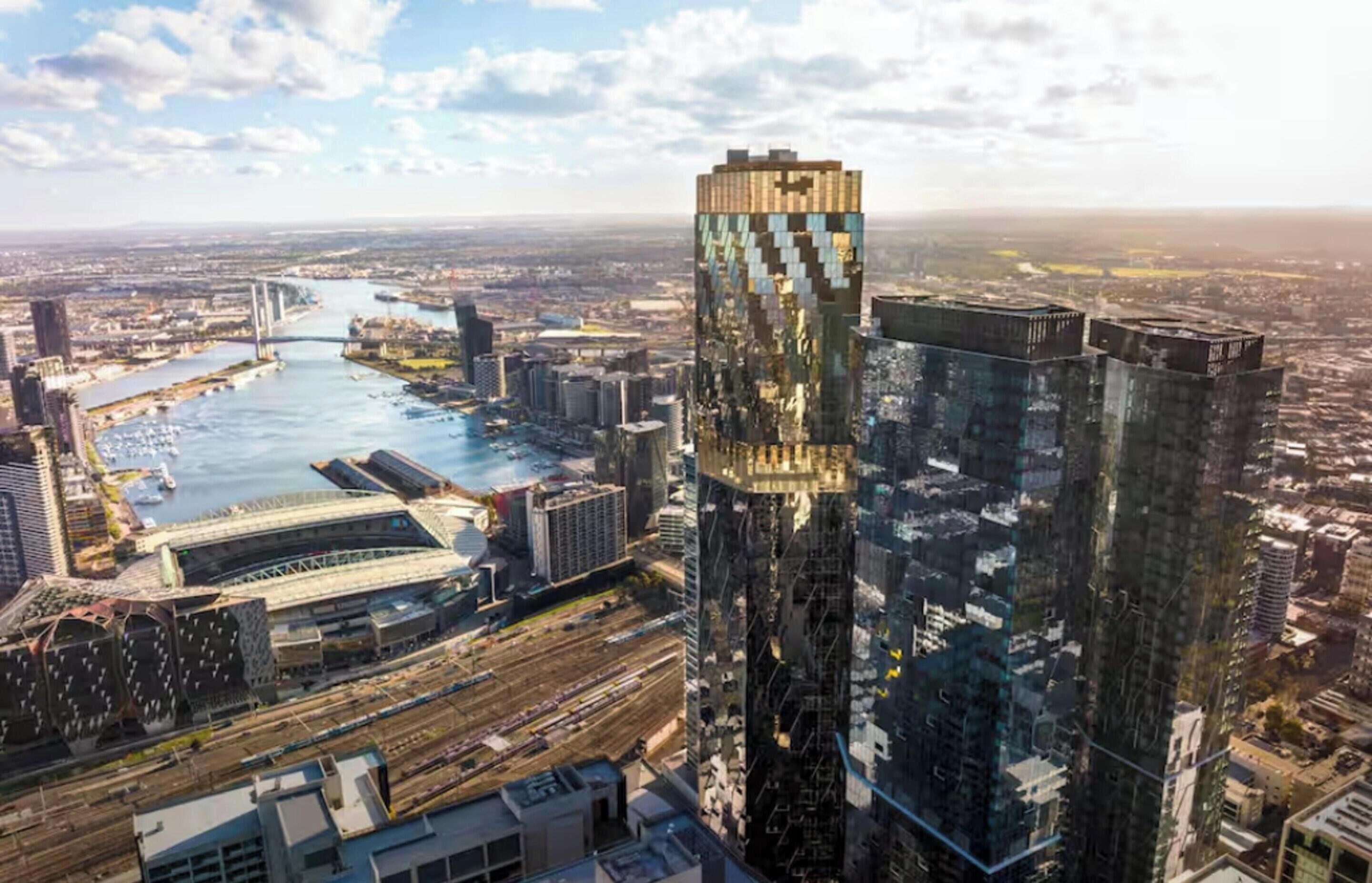 Ein Hochhaus mit auffälliger Glasfassade, umgeben von einem Fluss und anderen städtischen Gebäuden.