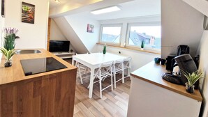 Een moderne keuken met een eethoek, een televisie en een koffieapparaat.
