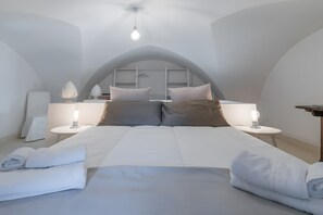 Ein Schlafzimmer mit einem großen Bett, zwei Nachttischen und einer Deckenleuchte.