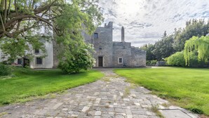 Un edificio histórico de piedra con un camino empedrado que lleva a su entrada.