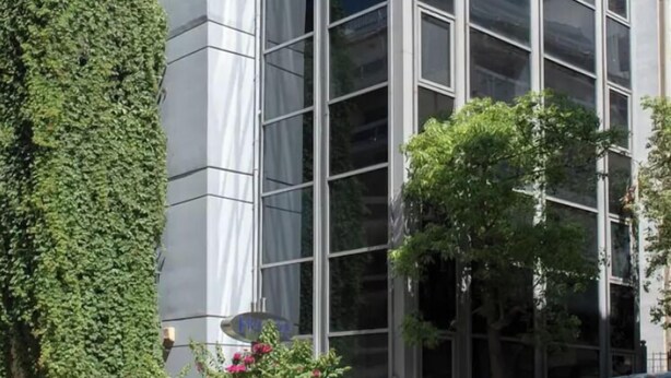 A modern building with large windows and a metal facade. - BES 6 - Minimal Studio by GHH (Kesariani)