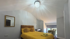A bedroom with a bed, a mirror, a chandelier, and a view of the outdoors. - Private room in Little Bridgeford (Stafford)