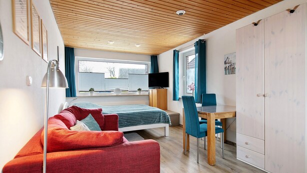 A modern room with a bed, a desk, a TV, and a wardrobe. - Apartment 'FeWo2' with Wi-Fi (Oesterdeichstrich)