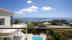 Ein modernes Gebäude mit Pool, Balkon und Meerblick.