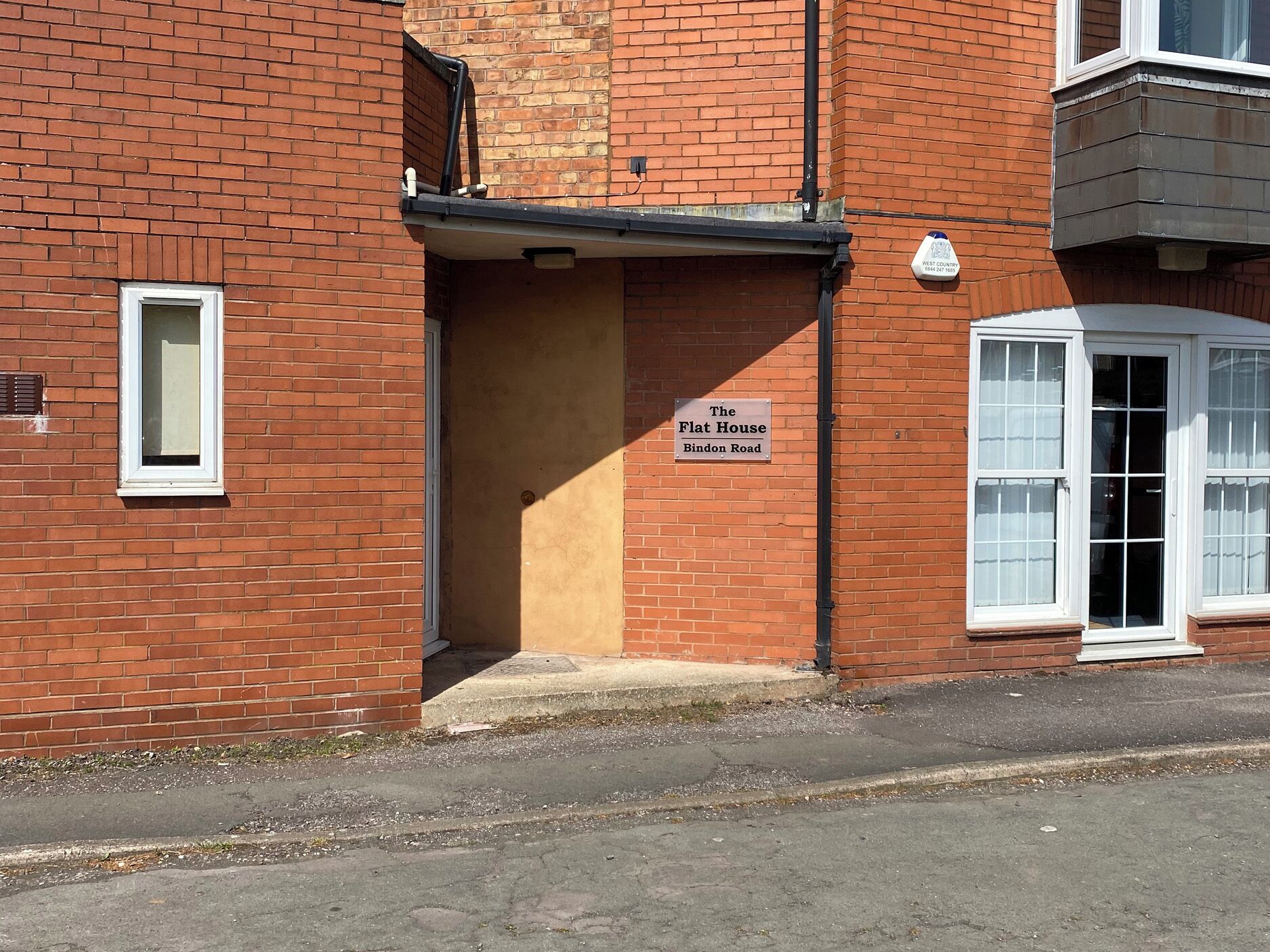 A brick building with a sign reading 'The Flat House Binden Road.'