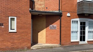 A brick building with a sign reading 'The Flat House Binden Road.' - The Flat House (Taunton)